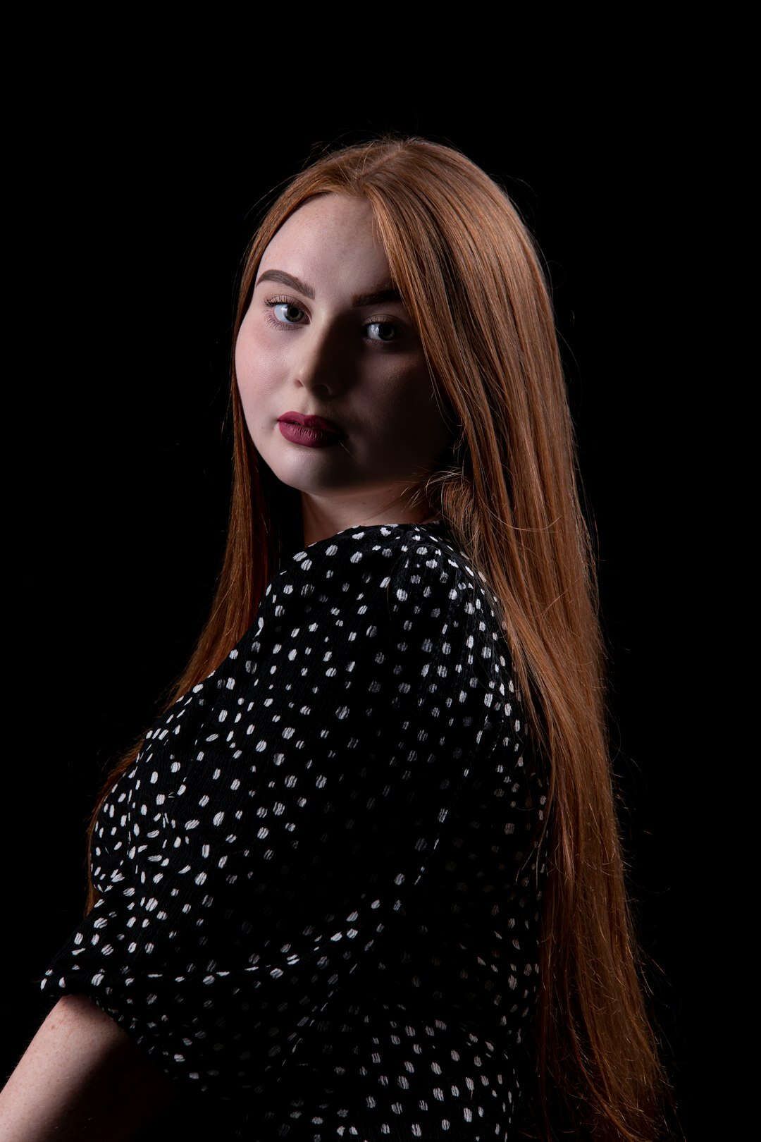 Studio portrait of a woman with long red hair